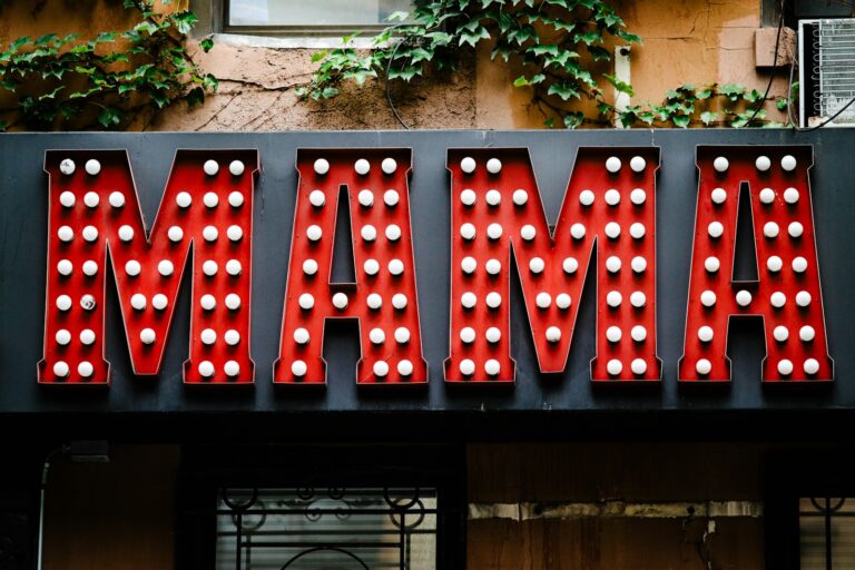 a neon sign that says mamma on the side of a building